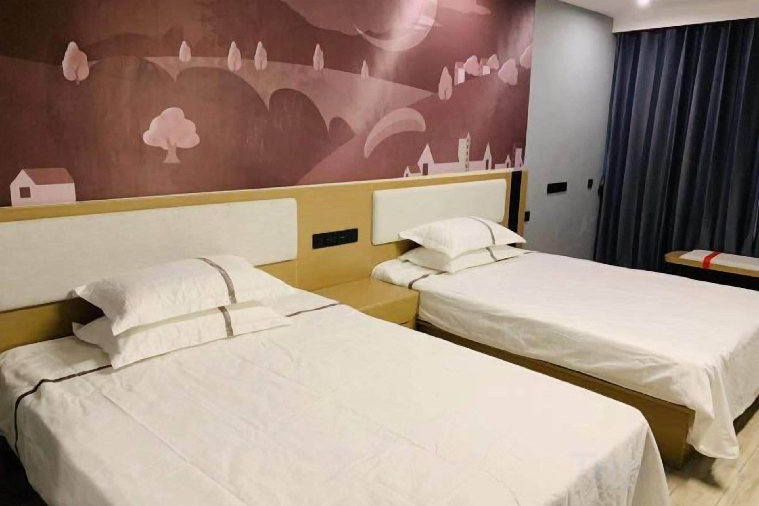Une chambre d’hôtel avec deux lits simples, une tête de lit et une fresque murale.