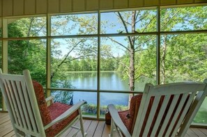 Relax in a serene seating area with a tranquil lake view, surrounded by lush greenery, and enjoy the peaceful ambiance.