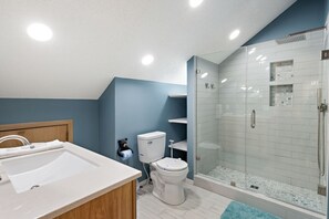 Un baño moderno con ducha, inodoro y lavamanos.