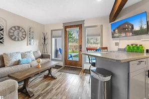 A modern kitchen with a wooden countertop, a built-in oven, and a dining area with a bench.