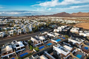 Un quartier résidentiel caractérisé par des logements compacts, des panneaux solaires et des piscines.