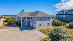 A two-story house with a covered porch and a staircase leading to the second floor. - Baliwest - Gorgeous 5 BR Oceanfront home with a panoramic ocean view! (Southern Shores)