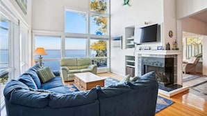 Ein geräumiges Wohnzimmer mit einem großen blauen Sofa, einem Kamin und einem Fernseher.