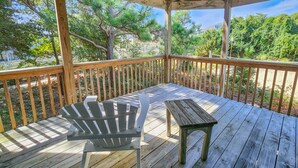 A wooden deck with a table and a chair, surrounded by a wooden railing. - YES ABSOLUTELY - Family Friendly 4BR Oceanside home in Duck w/Private Pool & Hot Tub (Duck)