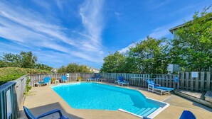 A rectangular swimming pool with a wooden deck, surrounded by a wooden fence. There are several lounge chairs and a small table near the pool. - YES ABSOLUTELY - Family Friendly 4BR Oceanside home in Duck w/Private Pool & Hot Tub (Duck)