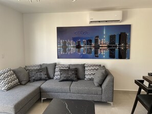 Relax in this stylish living room with a sofa, coffee table, and cityscape artwork.