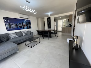 Relax in this stylish living space with a sofa, dining area, and fully equipped kitchen.