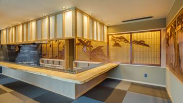 A traditional Japanese-style interior with tatami flooring, a reception desk, and shoji screens.
