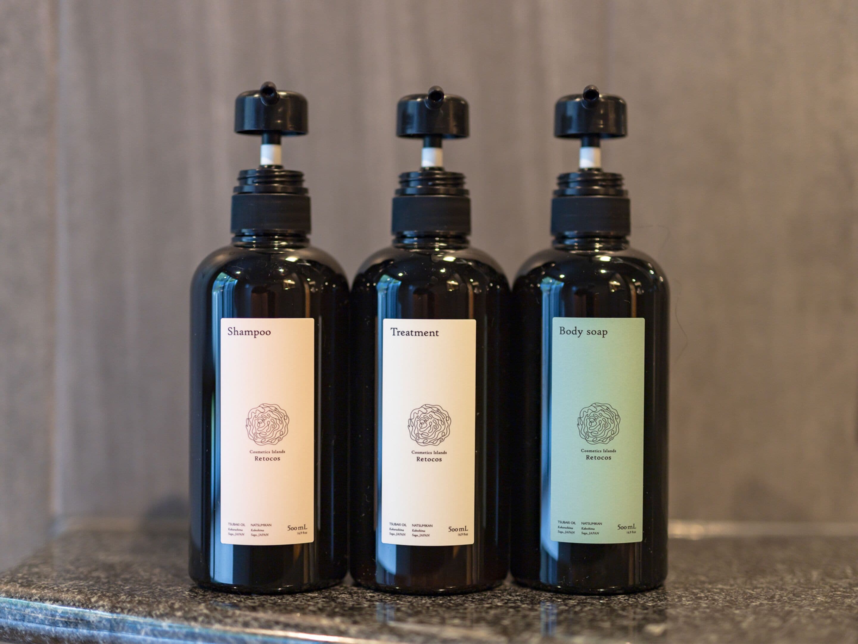Three bottles of toiletries on a countertop.