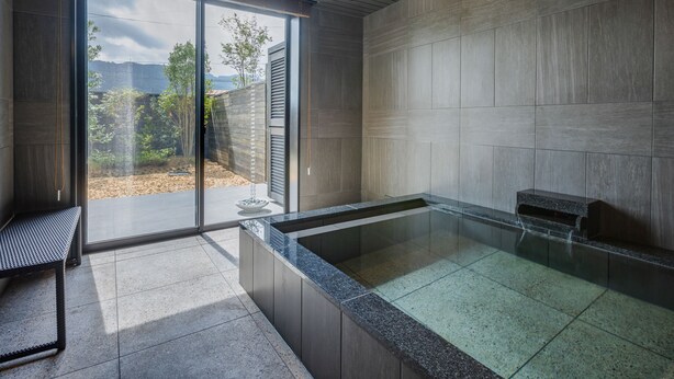 Un baño moderno con ducha de vidrio, un banco y vistas al exterior.