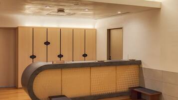 A reception desk with a wooden finish, a nameplate, and a bench.