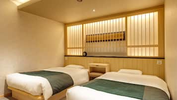 Une chambre d’hôtel avec deux lits, des panneaux de bois au mur, un petit bureau et une horloge fixée au mur.