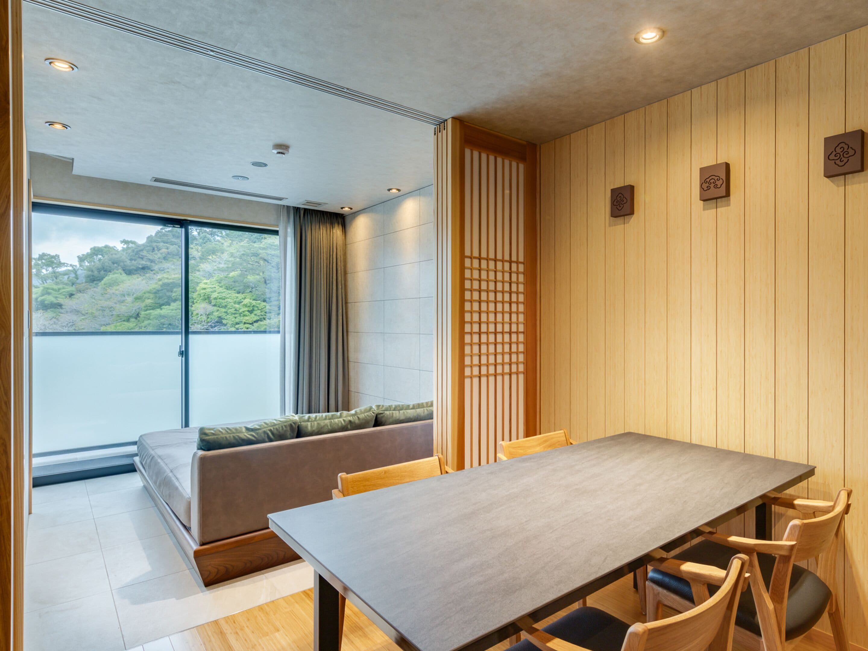 A modern dining area with a wooden table, chairs, and a cushioned bench.