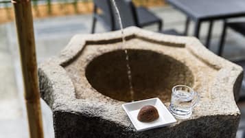 A stone well with a square plate and a glass of water.