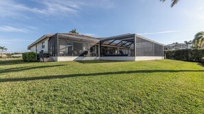 A modern house with a large covered patio area and a well-maintained lawn.