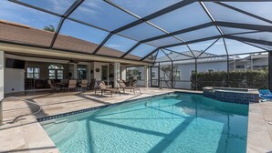 Un área de piscina al aire libre techada, con sillones de descanso y una terraza.