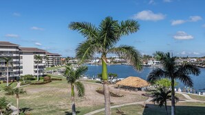 Ein Resort mit Blick auf das Wasser, Palmen und einem Gebäude mit mehreren Balkonen.