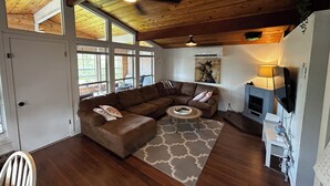 Ein gemütliches Wohnzimmer mit einer Eckcouch, einem Couchtisch und einem Fernseher.