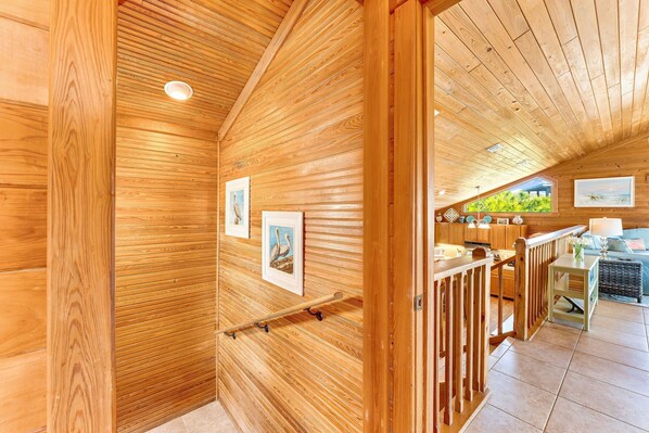 A wooden interior with a wooden ceiling, a wooden bench, and a wooden railing.