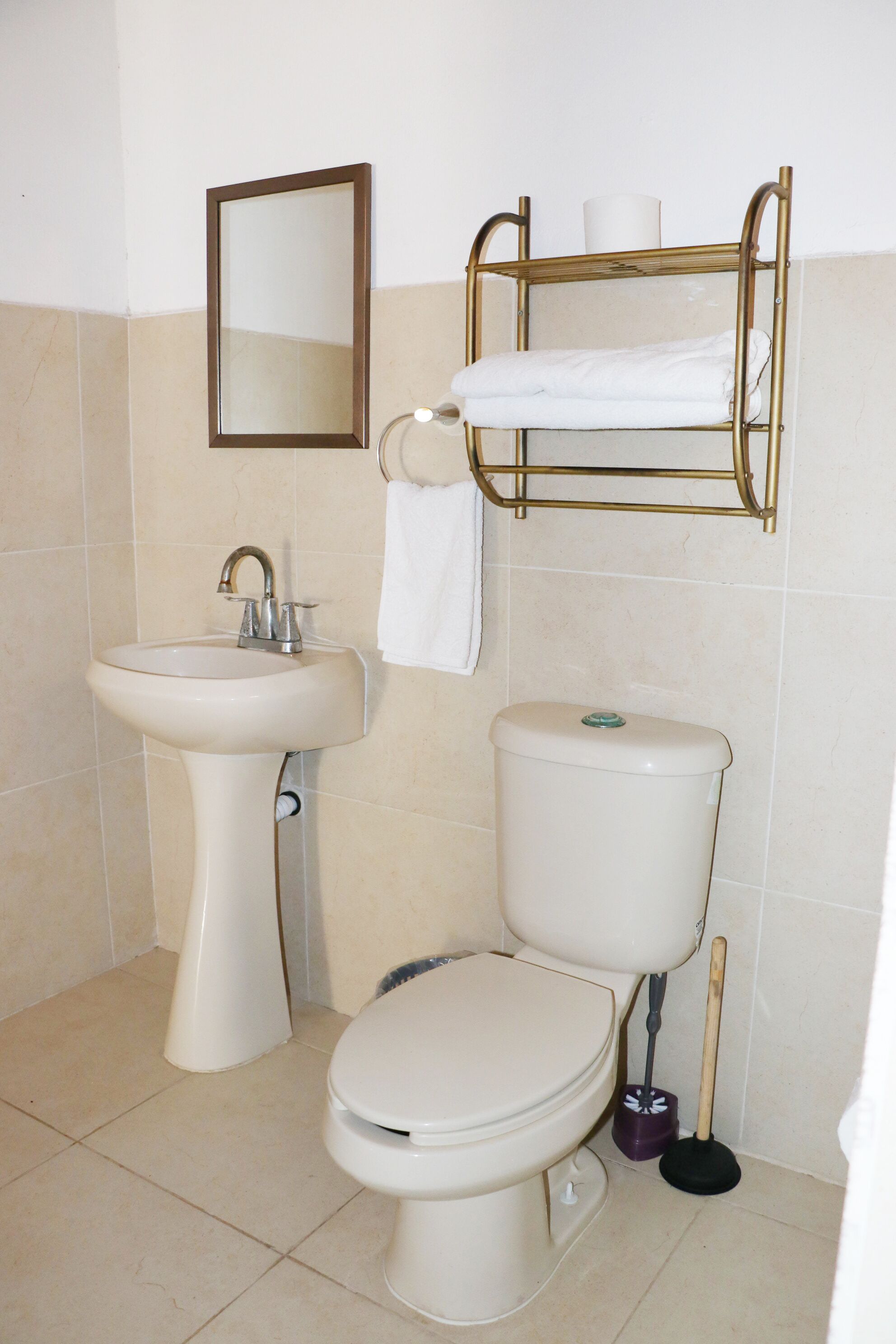 A bathroom with a sink, toilet, and a towel rack.