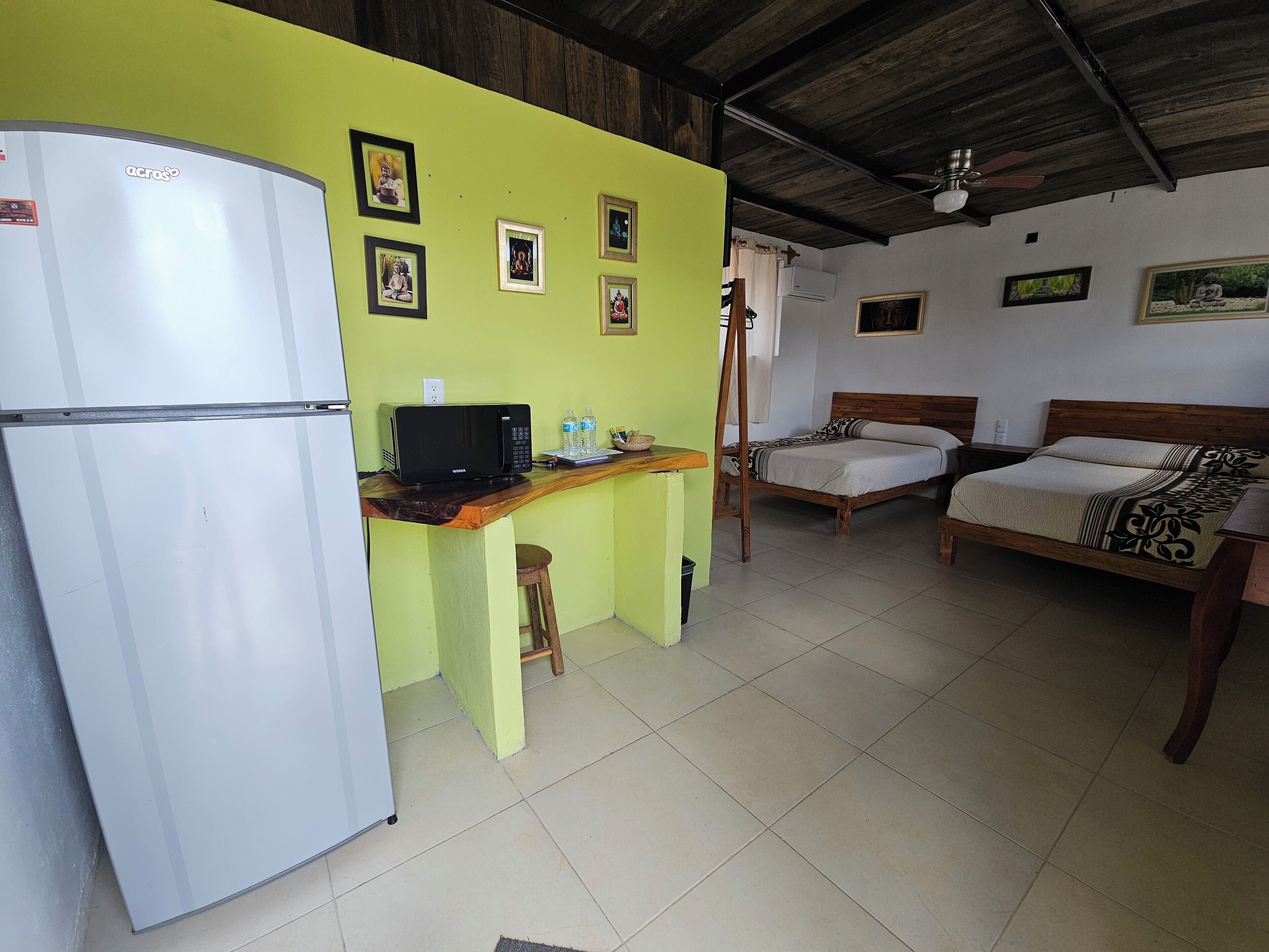A compact room with a kitchenette, a bed, and a desk.
