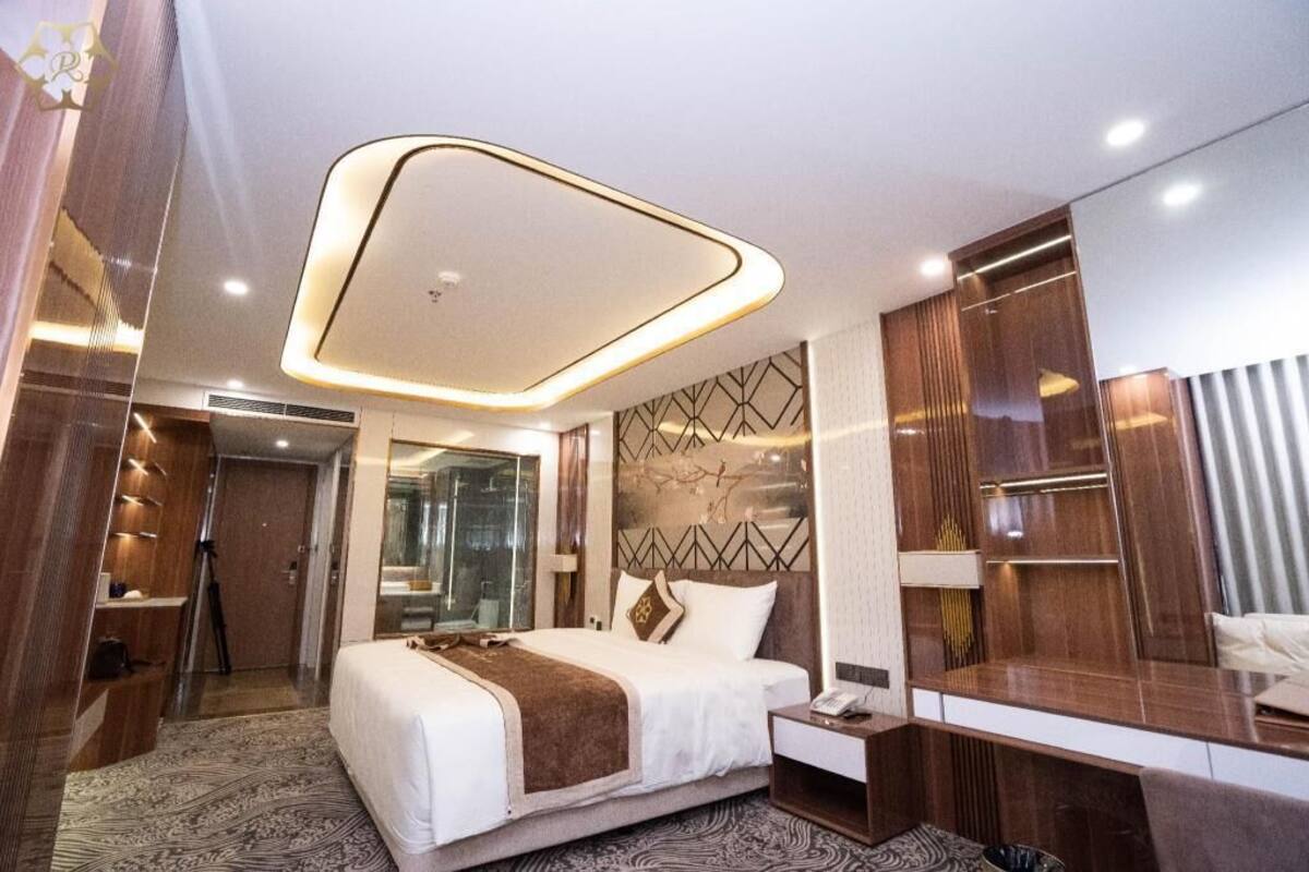 Une chambre d’hôtel moderne, dotée d’un grand lit, d’un bureau et d’une armoire.