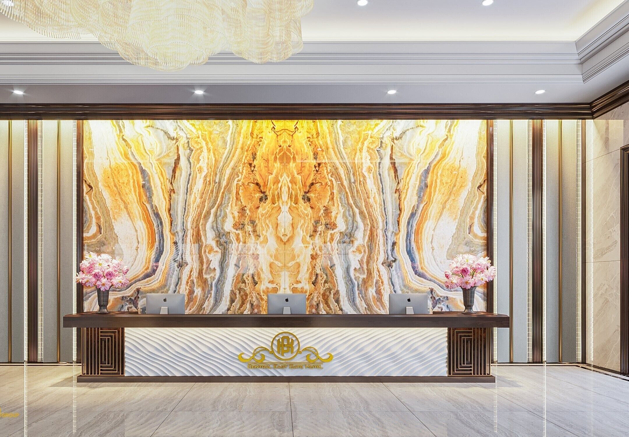 A reception desk with a marble wall backdrop, two computers, and a logo.