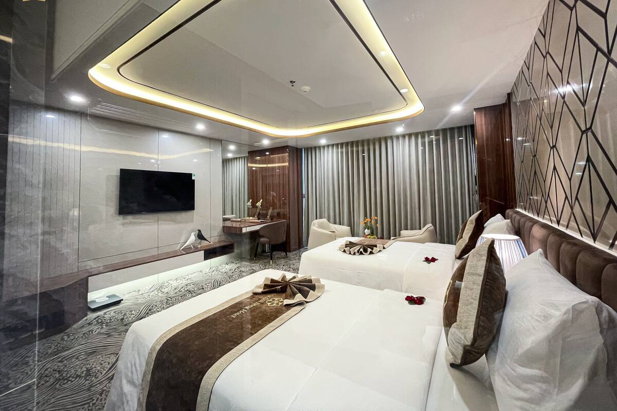 Une chambre d’hôtel moderne avec un grand lit, un bureau et une télévision.