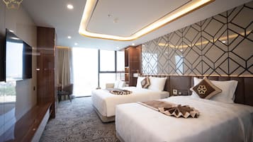 A hotel room with two beds, a large window, and a modern design.