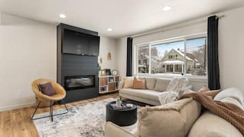 Smart-tv, eldstad, ett bordtennisbord och datorskärmar