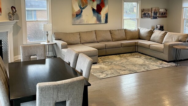 A modern living room with a sectional sofa, a dining table with chairs, and a fireplace. - 2026 Virginia Tech Graduation Home with Mountain Views ~4 miles to VT (Blacksburg)