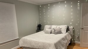 A bedroom with a bed, bedside table, and a wall-mounted fan. - 2026 Virginia Tech Graduation Home with Mountain Views ~4 miles to VT (Blacksburg)