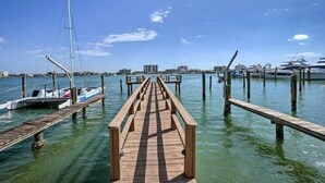 A wooden pier leading to a marina with boats docked.