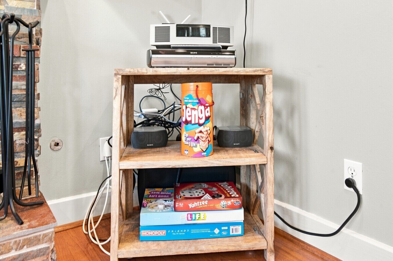 A wooden shelf with a Sony air conditioner, a Jenga game, and a Monopoly board game.