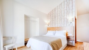 Ein ordentlich eingerichtetes Schlafzimmer mit Bett, Nachttisch, Lampe und Stuhl.