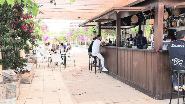 An outdoor café with tables and chairs, a bar area, and potted plants. - Lorca - Cottage - Sleeps 4 - Pet Friendly - Pool (Lorca)