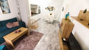 A modern living room with a sofa, coffee table, and dining area. - RentalSevilla 3 bedroom apartment in Triana (Sevilla)