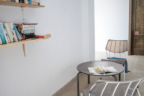 A room with a bookshelf, a round table with a chair, and a door with a 'no entry' sign.