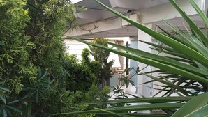 Blick ins Innere eines Gebäudes, im Vordergrund eine Topfpflanze und im Hintergrund eine Treppe.