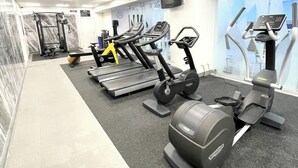 A gym with treadmills, elliptical machines, and weight equipment. - Perfect City Pad (Auckland)