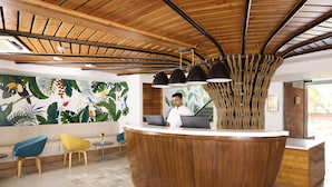 A reception area with a wooden reception desk, a colorful mural, and modern seating.