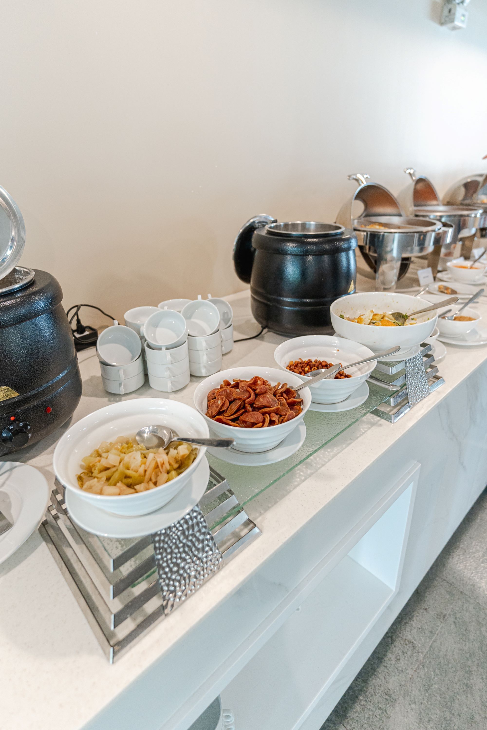 A buffet setup with various dishes and serving utensils.