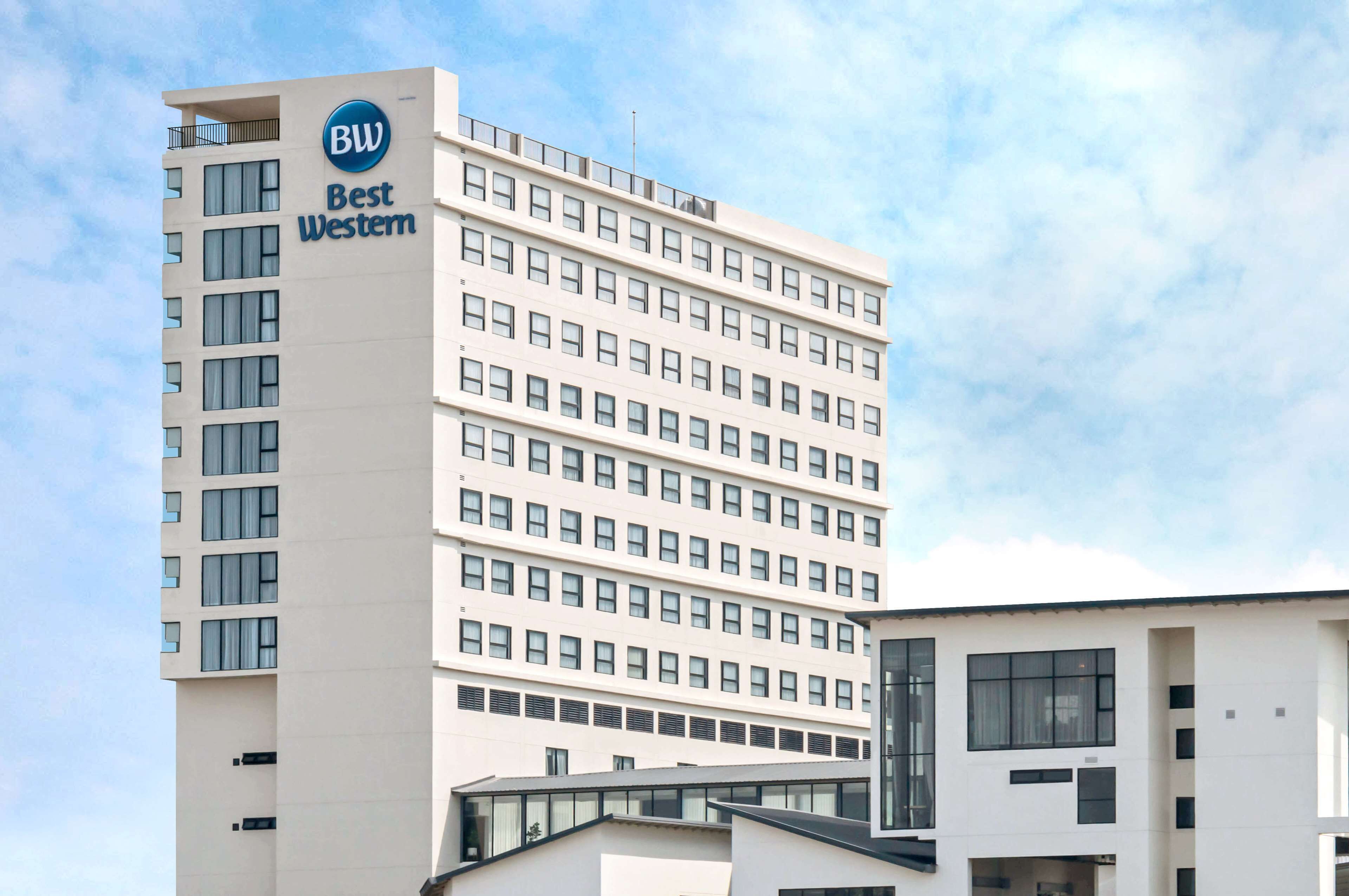 Ein hohes Hotelgebäude mit einem 'Best Western'-Schild, das mehrere Stockwerke und ein modernes architektonisches Design aufweist.