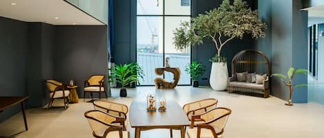 Interior moderno com área de refeições, assentos e uma grande janela com vista para um canteiro de obras.