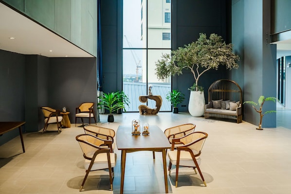 A modern interior with a dining area, seating, and a large window with a view of a construction site.