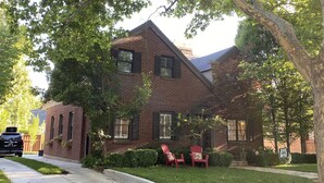 A two-story brick house with a sloped roof, a front porch, and a driveway. - Luxury Home For Rent NBA All Star Weekend (Salt Lake City)