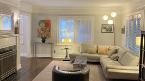 A living room with a fireplace, a sofa, a coffee table, and a rug. - Luxury Home For Rent NBA All Star Weekend (Salt Lake City)