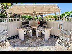 Enjoy al fresco dining with two gas grills under a covered pavilion, complete with a fire extinguisher for added safety.