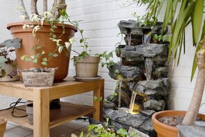 A wooden table with potted plants and a small waterfall feature. - Studio Apartment 'Lindenhardt' with Shared Garden and Wi-Fi (Creussen)