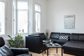 A modern living room with a sectional sofa, a coffee table, and a potted plant.